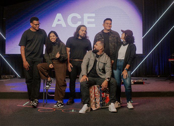 Integrantes da ACE Worship no palco, em frente a um telão com o logo ACE.